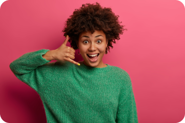 pretty-delighted-woman-makes-phone-sign-tells-call-me-back-smiles-happily-communicates-with-gestures-dressed-green-sweater-poses-pink-wall-dont-forget-call-being-touch 1 (1)
